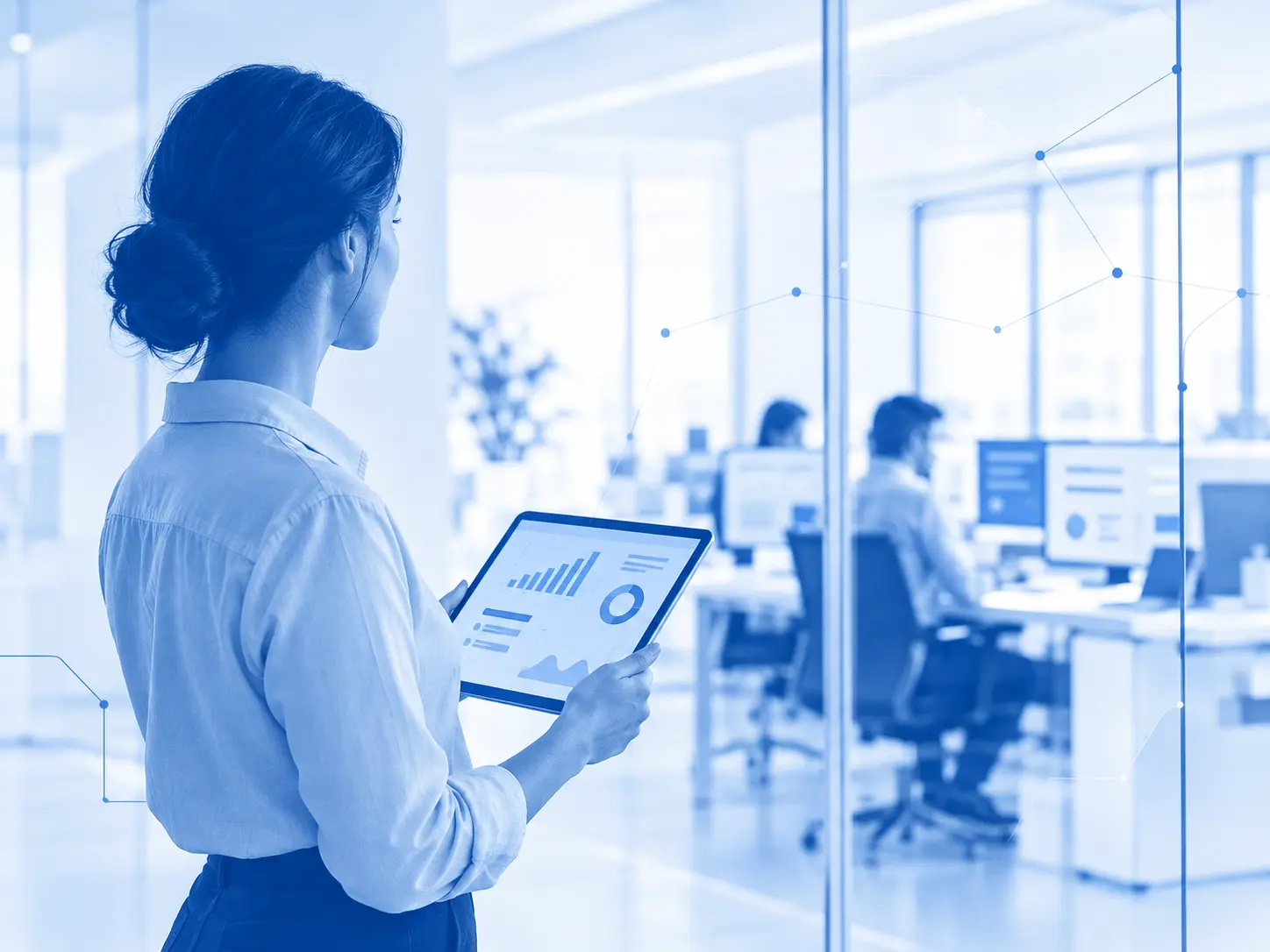 Gestor a acompanhar os indicadores da empresa num tablet, com a operação a decorrer em segundo plano